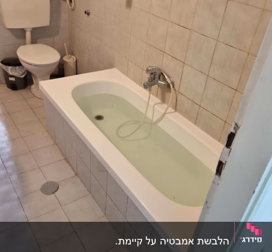 אמבטיה עם מים בחדר רחצה פשוט